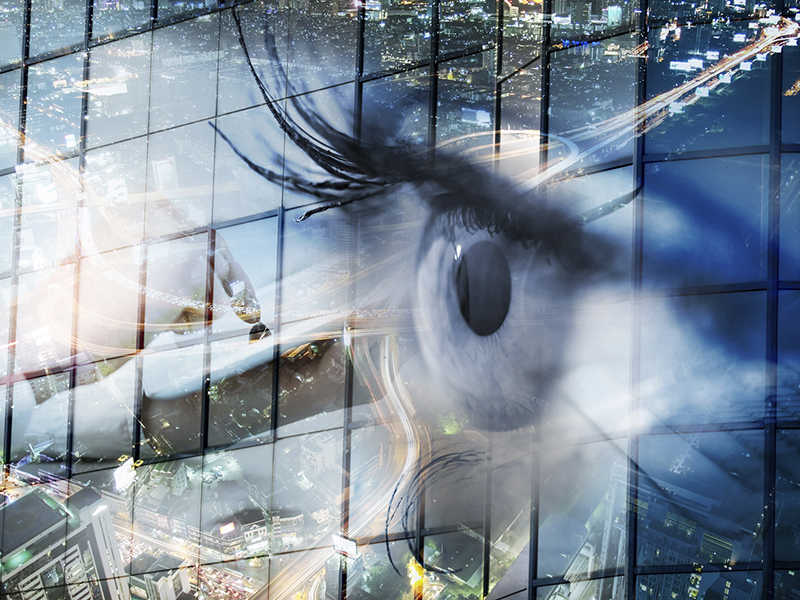Eye looks to the future business. Woman's eye in the double exposure of a modern city and technology.Eye looks to the future business. Eye women in double exposure with charts and diagrams business.